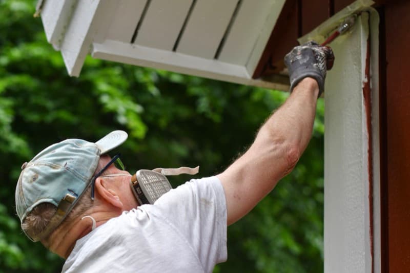 Painter maintaining the exterior of a rental property