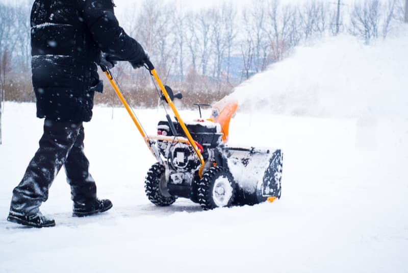 Snowblower clearing a residential driveway after snowfall