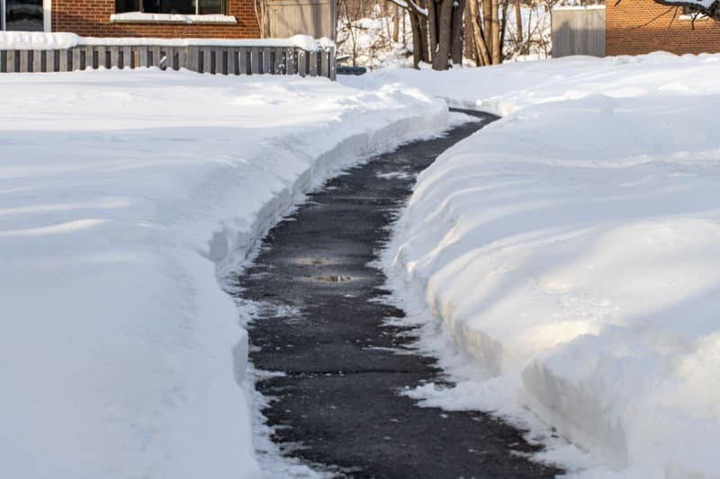 Cleared walkway through deep snow near residential homes